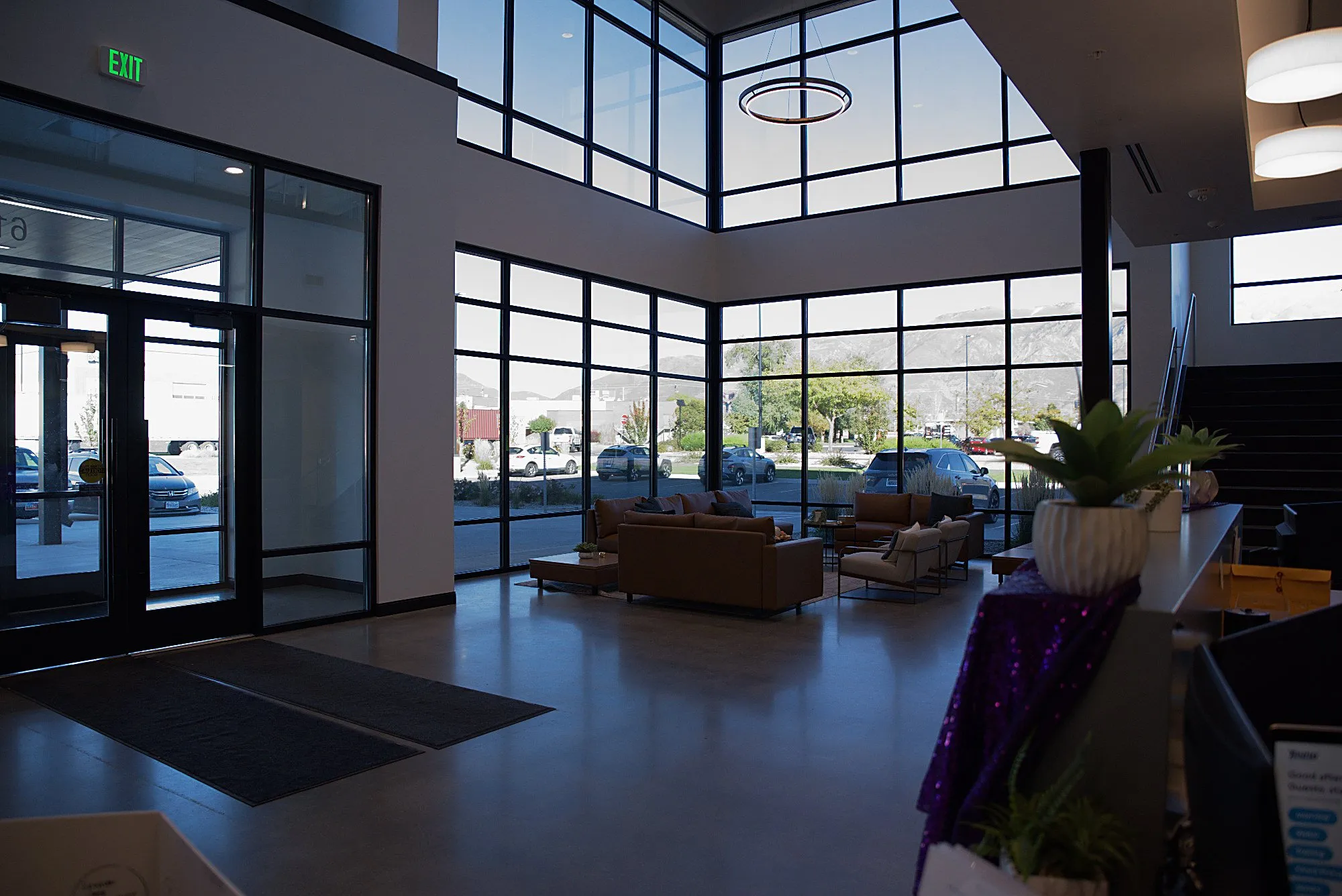 The entrance atrium from inside, glass doors and stairs in morning light