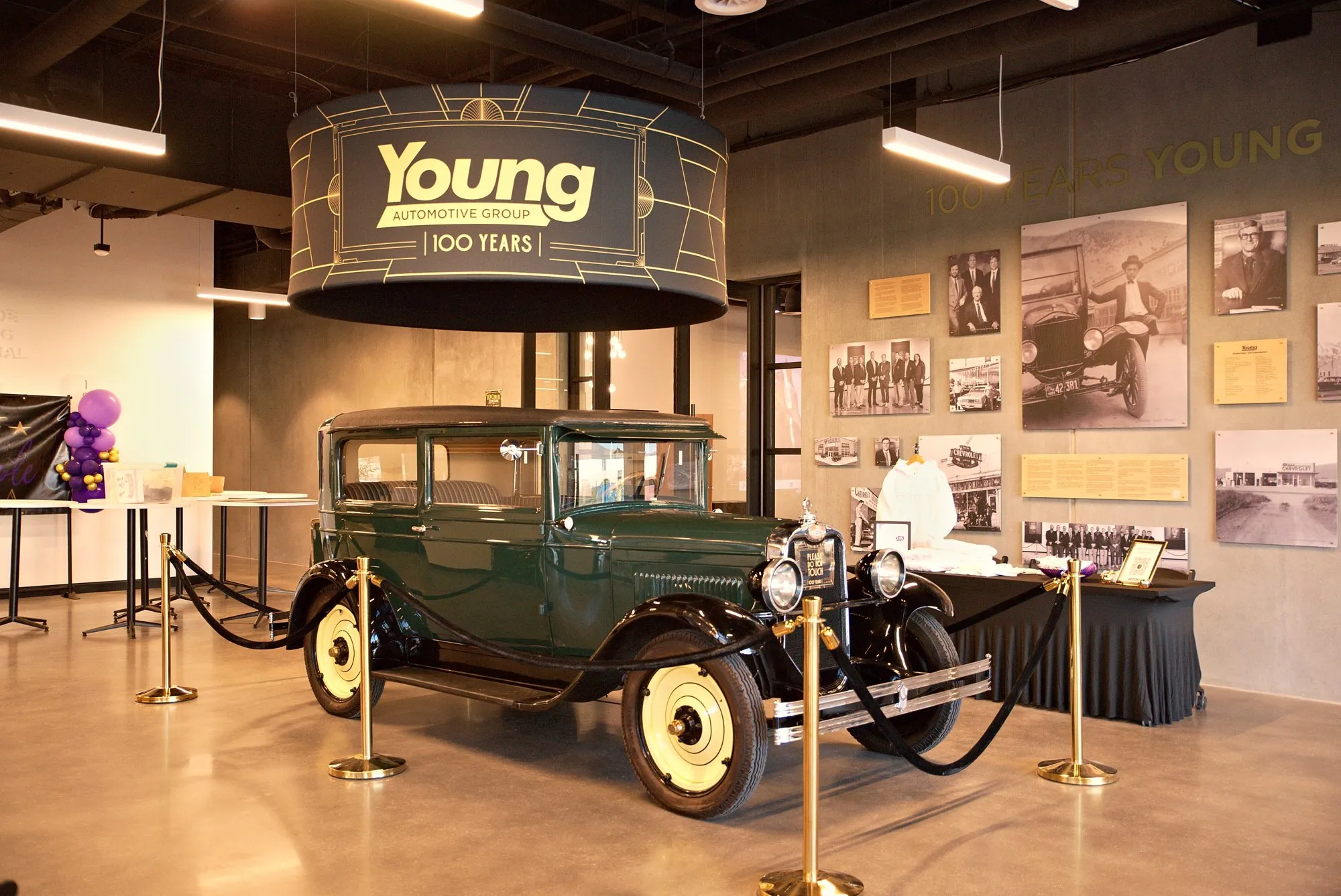 A 1920s Young Motor truck under the hundred-years sign beside a wall of archive photographs