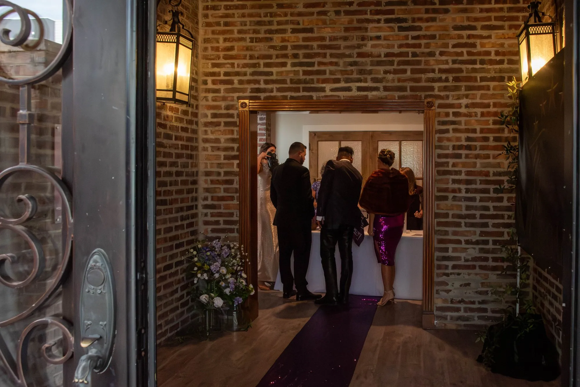 Guests arriving through the venue entry, framed by a brick doorway