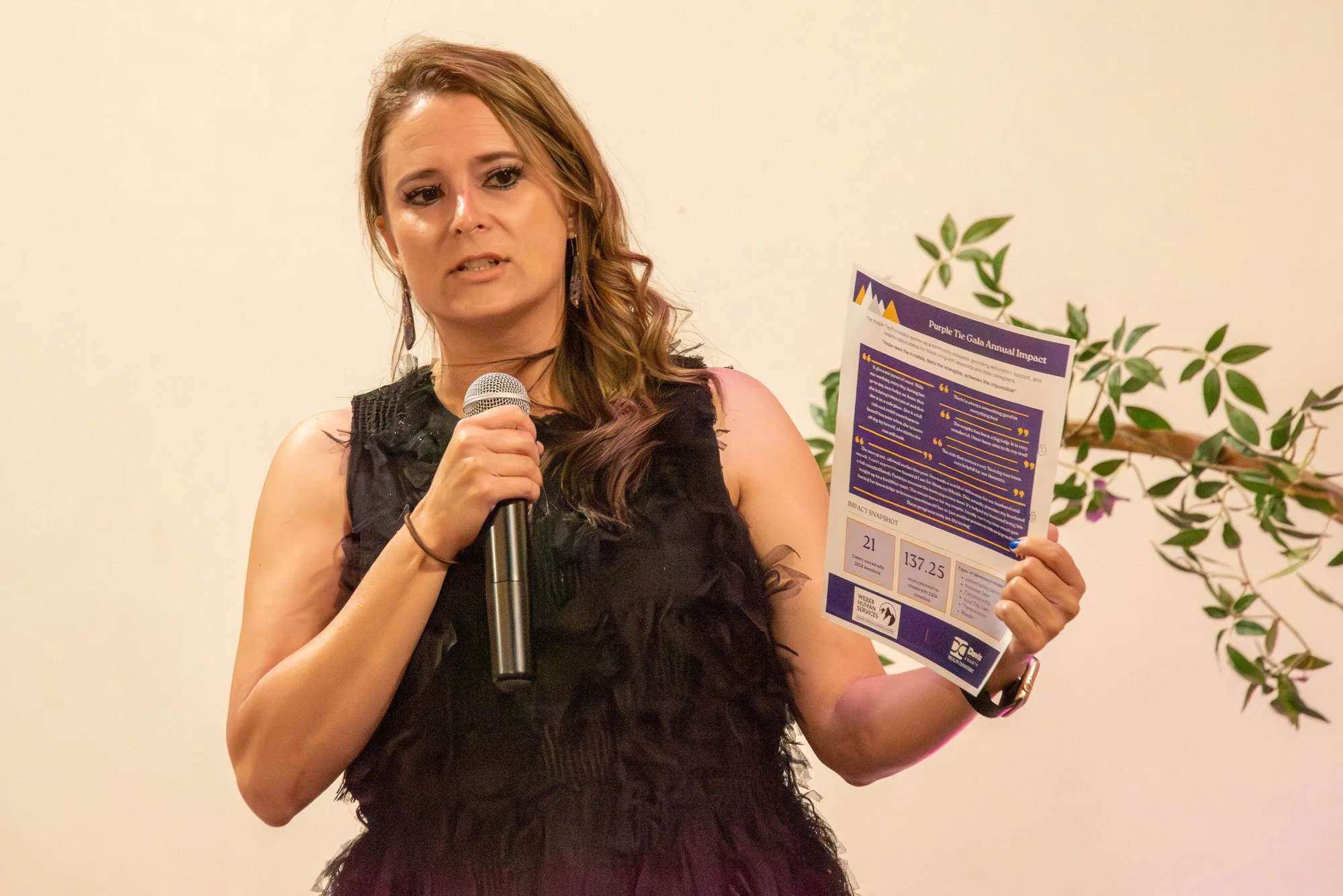 Speaker addressing the room with a microphone and printed remarks
