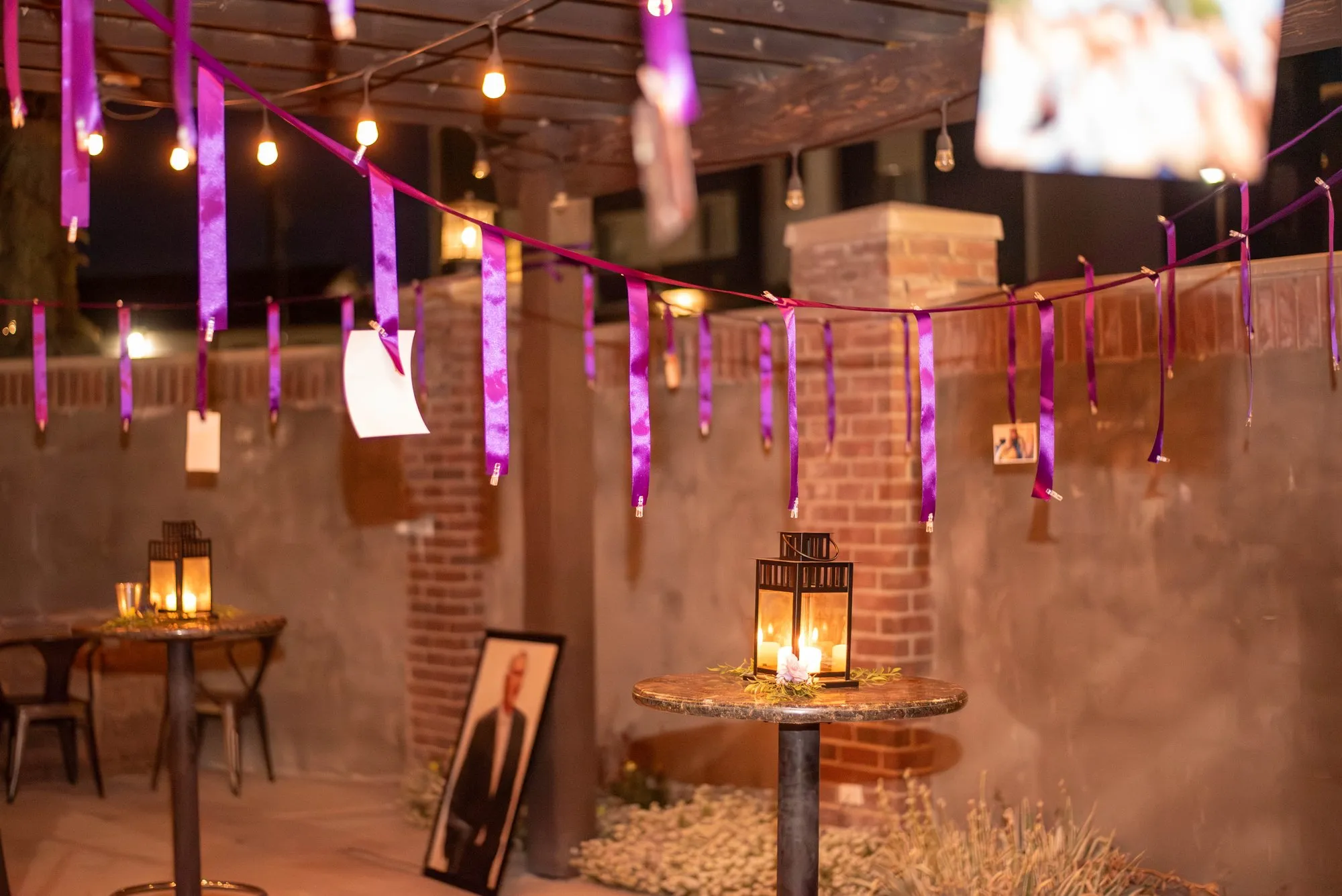 Hanging ribbon and lantern decor in a purple-lit corner of the venue