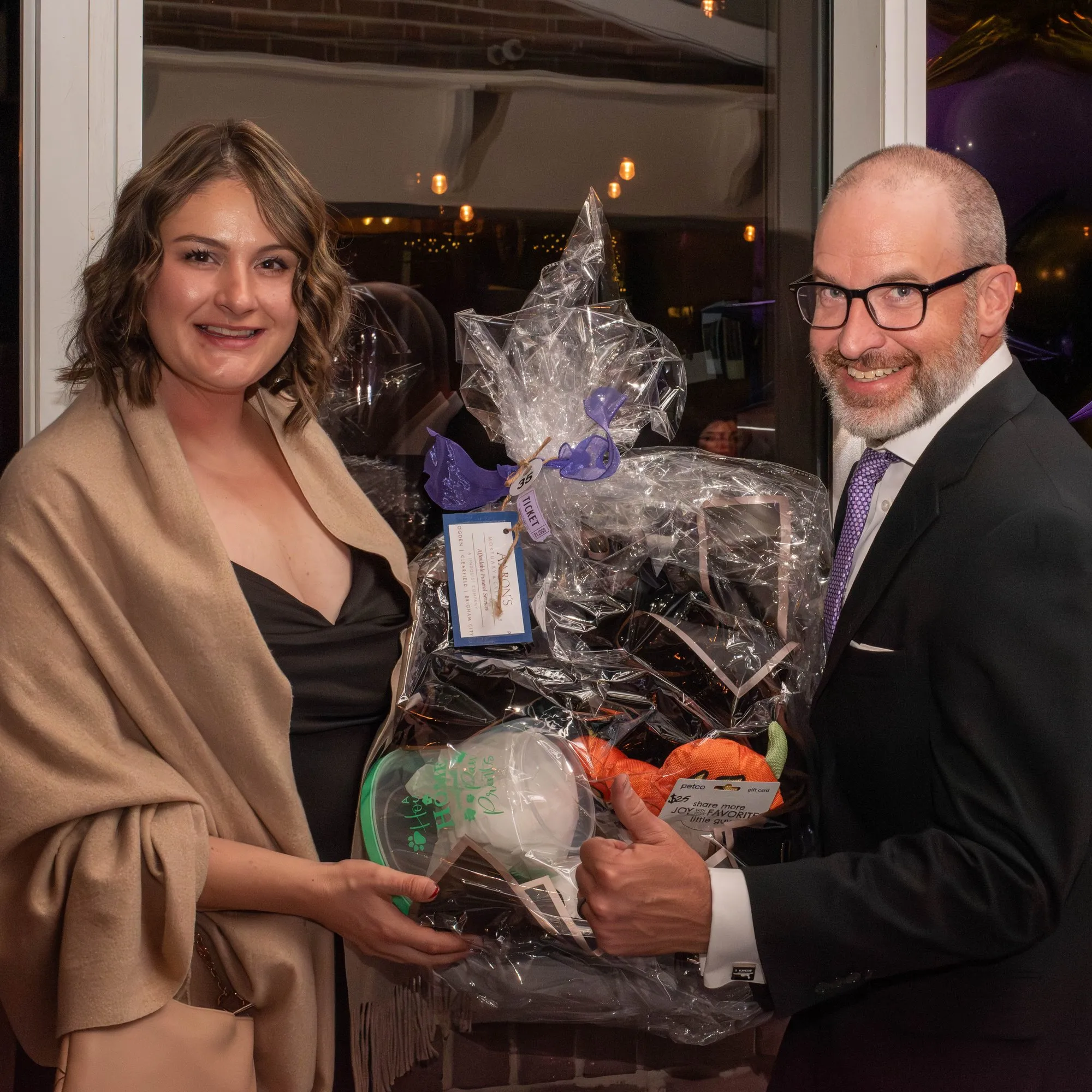 Silent auction winner holding her basket beside the organizer