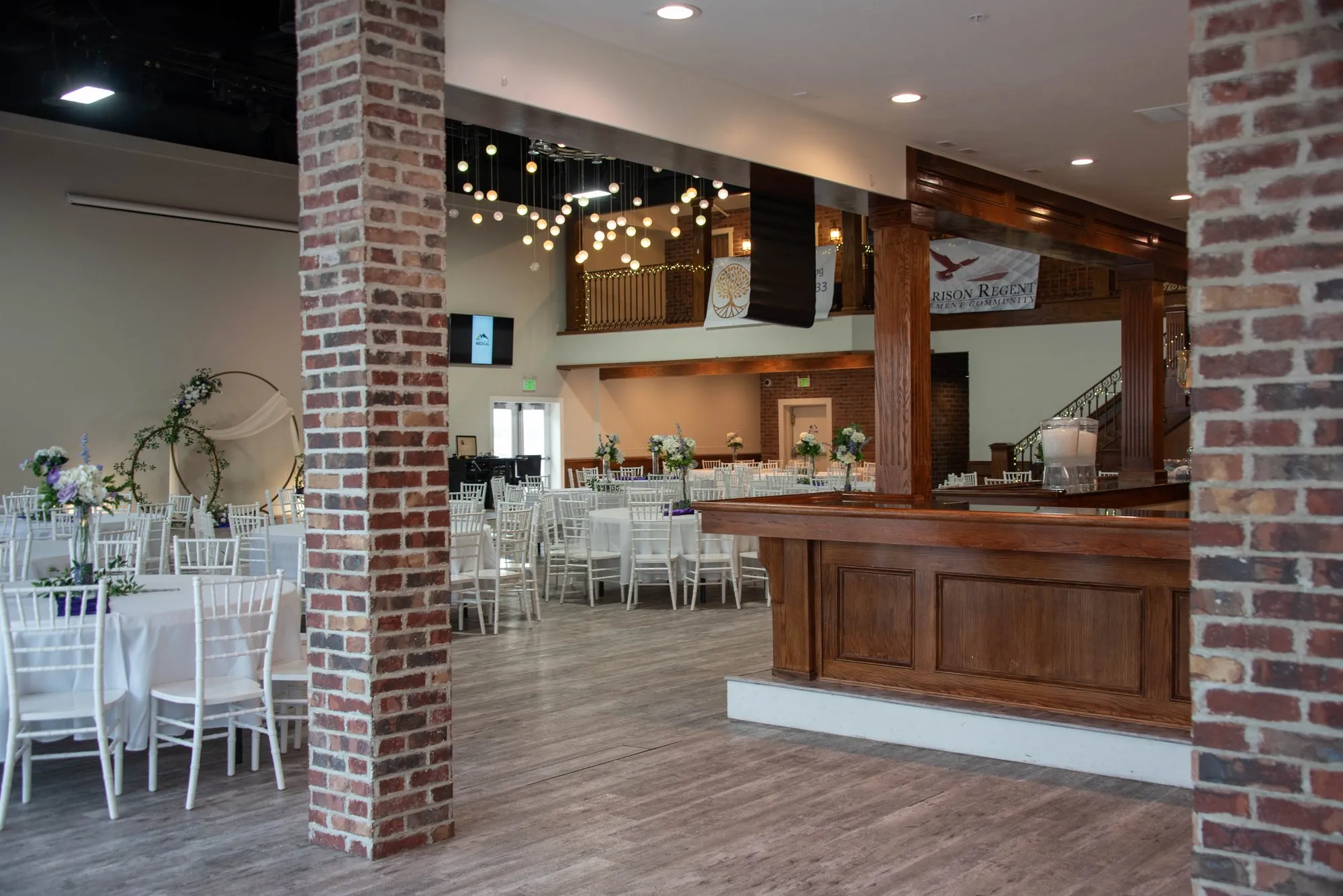 Empty venue with brick walls and white chairs, set and waiting for guests