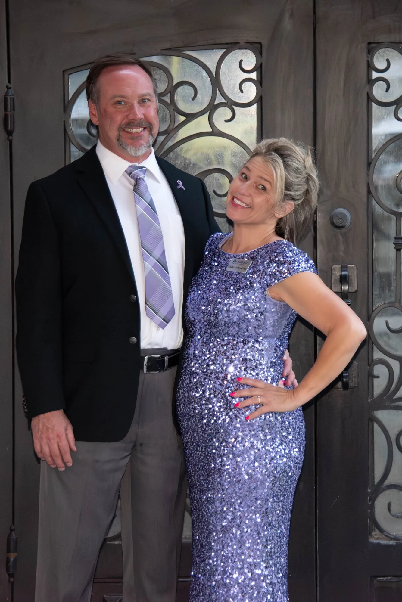 Couple posing at the iron entry doors of the venue