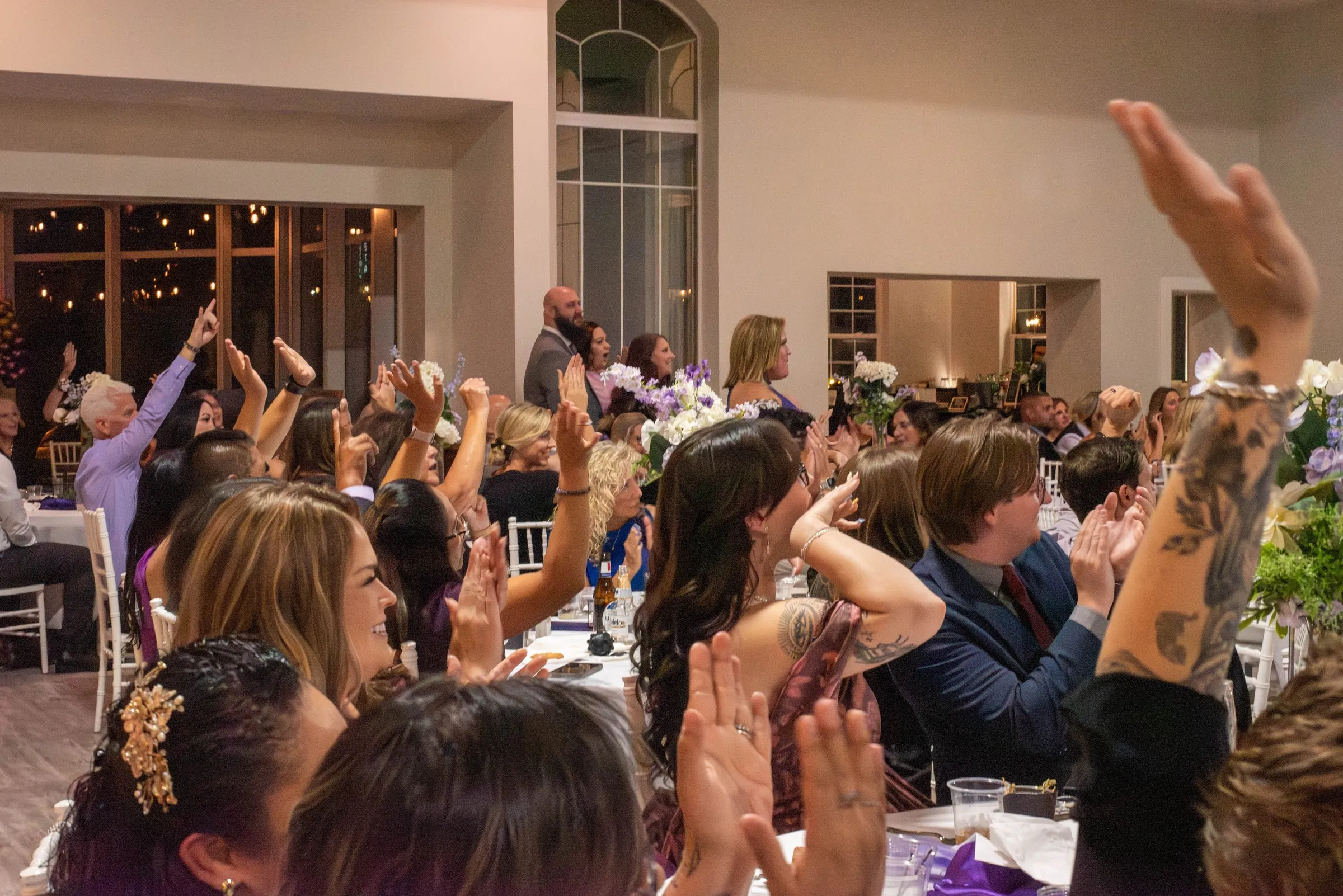 Gala guests on their feet, clapping and raising their arms as a winner is announced