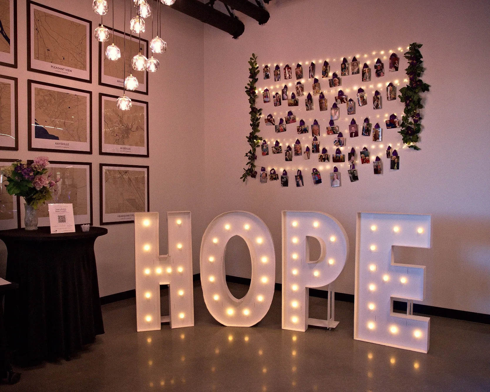 HOPE marquee letters lit under a wall of pinned family photographs before the gala doors open