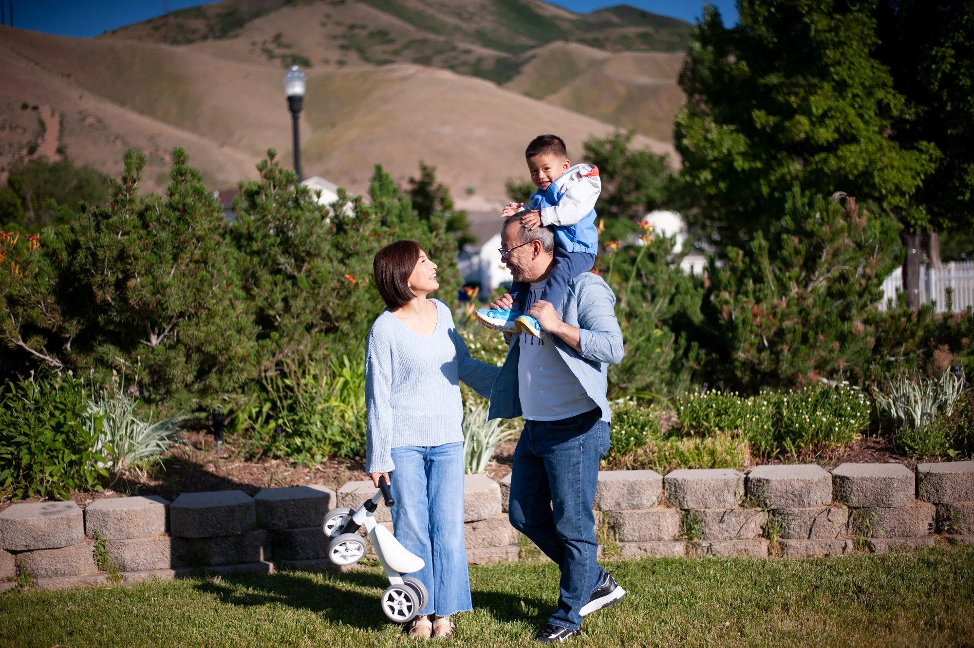 Three generations posing together with a hillside behind them