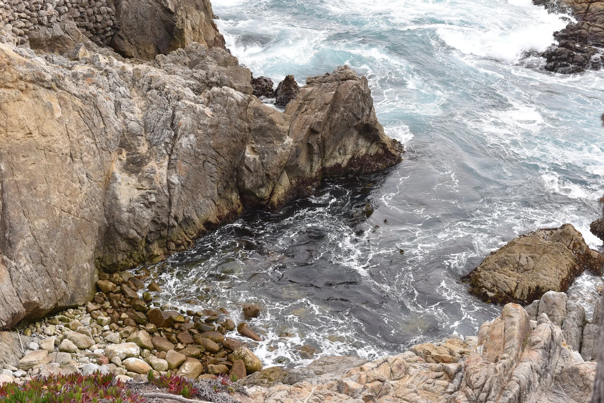 Surf breaking over dark rocks on the Monterey coast