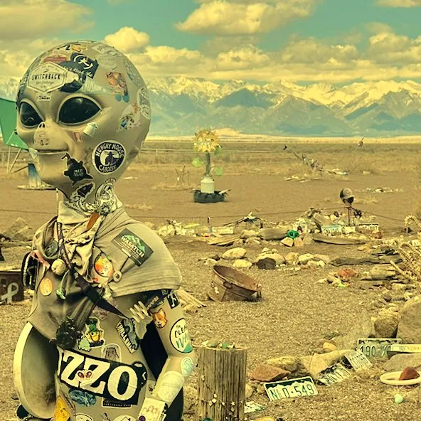 Alien figurine posed in the desert with a vintage film look
